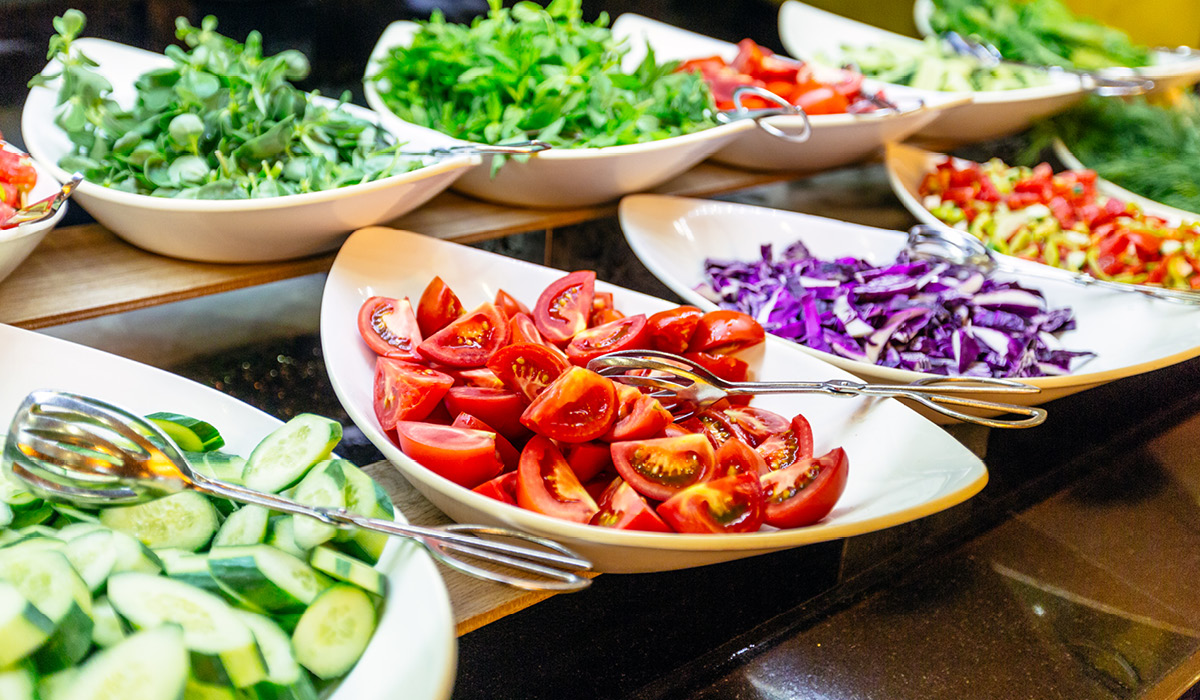 A salad bar with full serving vessels